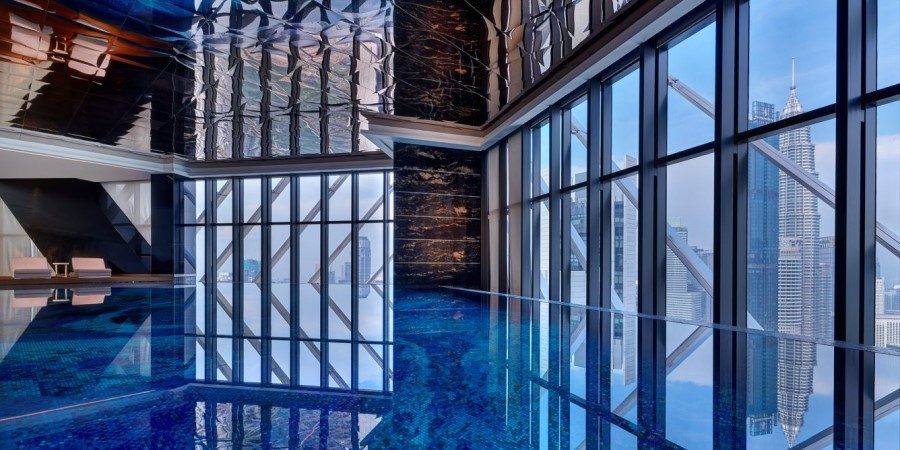Hotel pool view highlighting its grand architecture and scenic landscape under sunny weather.